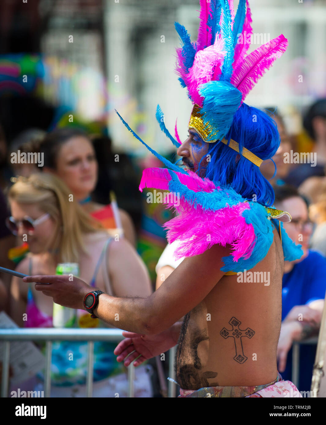 NEW YORK - 25 juin 2017 : un homme portant une coiffe de plumes flamboyant effectue pour les spectateurs lors de l'Assemblée gay pride parade à Greenwich Village. Banque D'Images