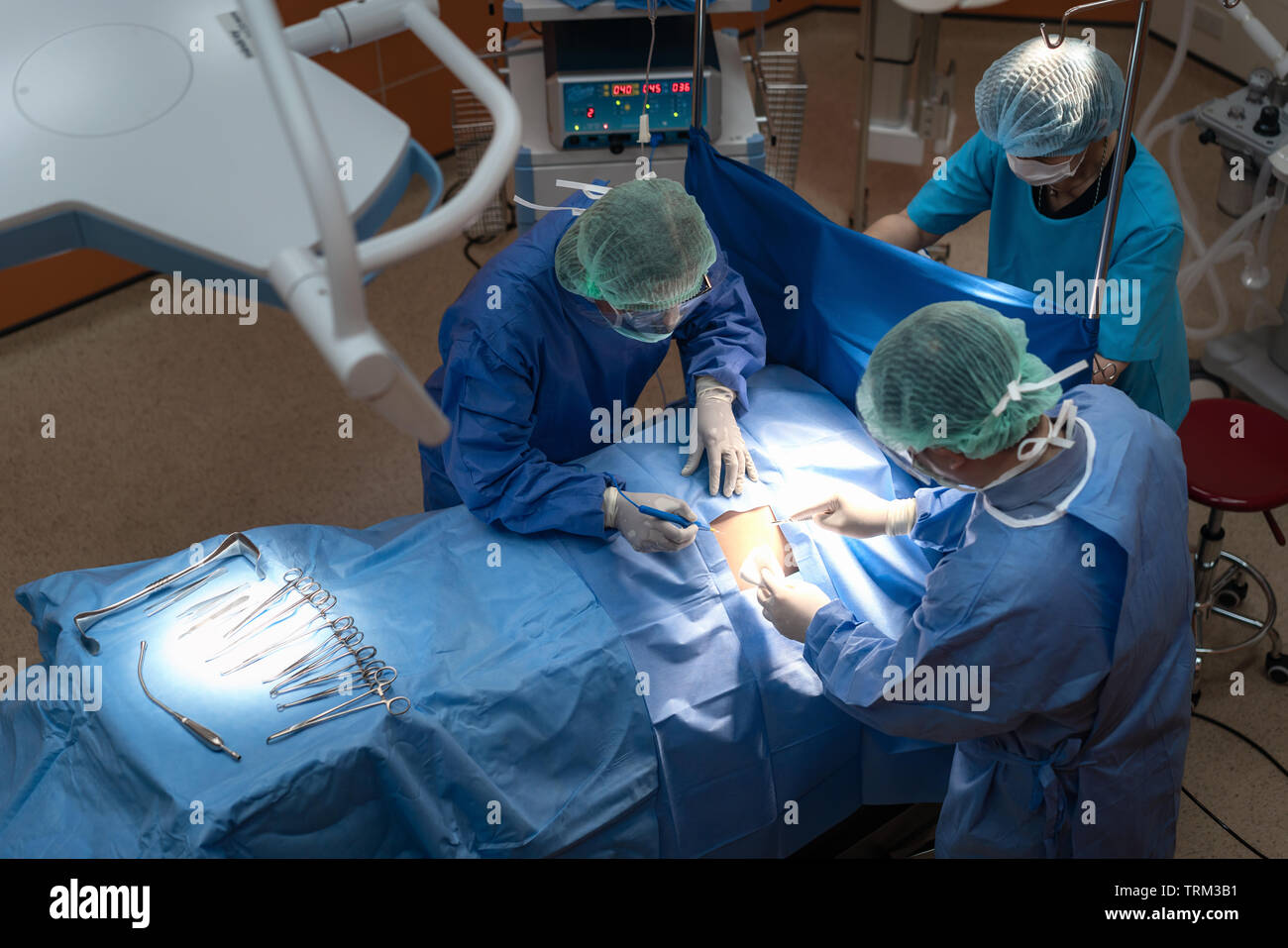 Groupe de chirurgiens au travail en salle d'opération. L'équipe médicale performing operation Banque D'Images
