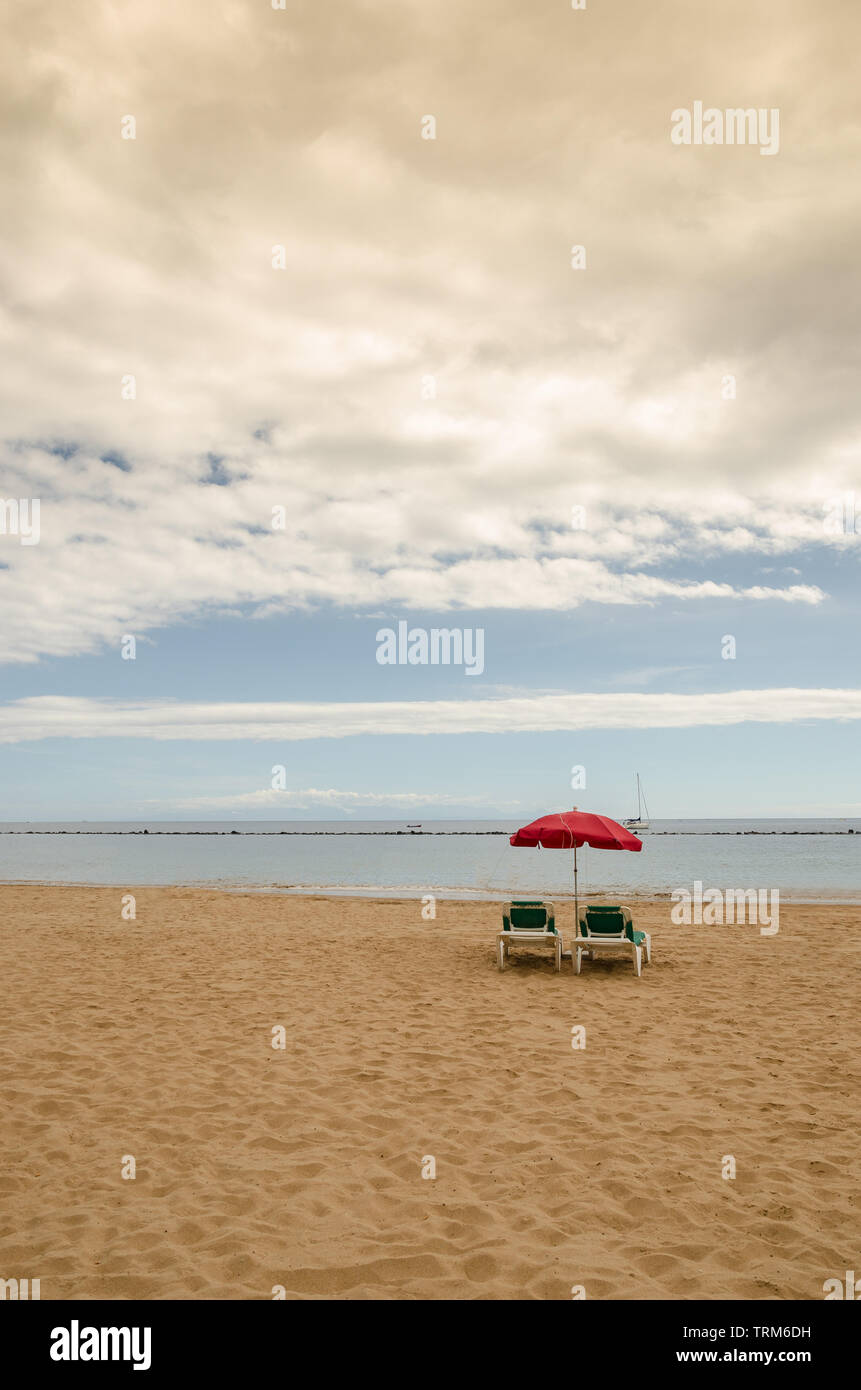 Assez simple. Matin en mer. Deux chaises longues qui l'attendrait et sous un parapluie. Admirer tout le paysage. L'ensemble de l'étendue d'eau Banque D'Images