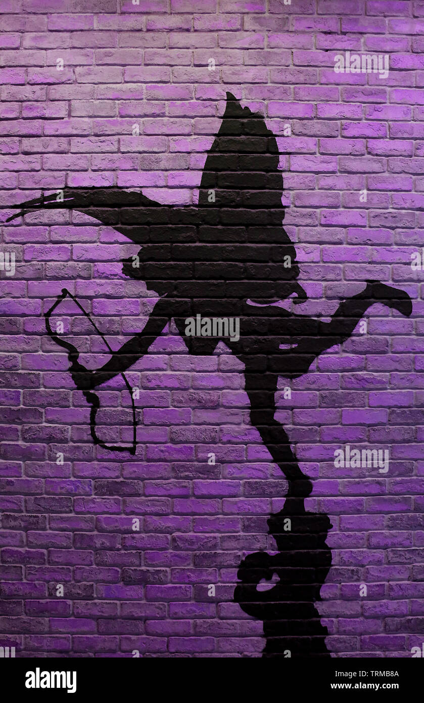 Image verticale du mur de brique violet avec la peinture de Cupid's silhouette Banque D'Images