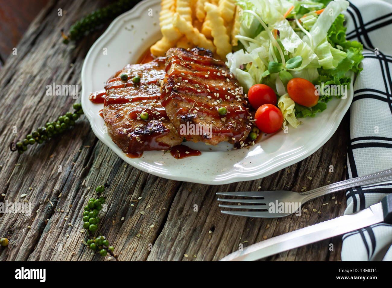 Escalope de porc avec la sauce dans une assiette blanche sur une table en bois Banque D'Images