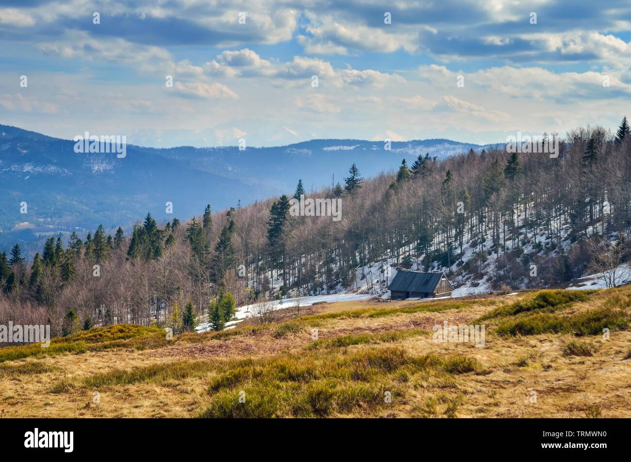 Printemps fabuleux paysage de montagne. Chalet en bois sur une clairière sur une colline. Banque D'Images