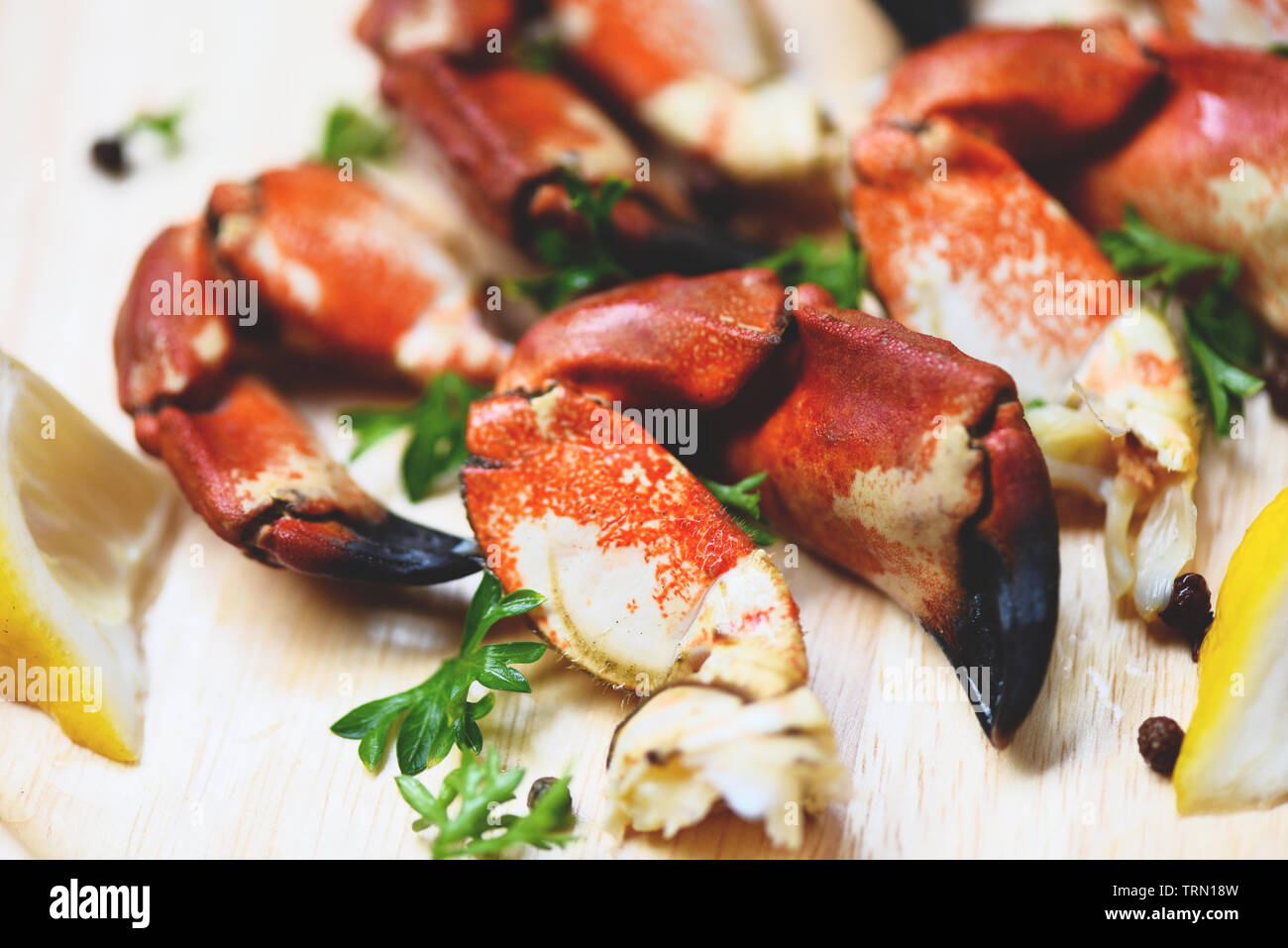 Les crabes cuits bouillis sur planche de bois avec du citron sur l'assiette de fruits de mer servi / Red stone crab claw Banque D'Images