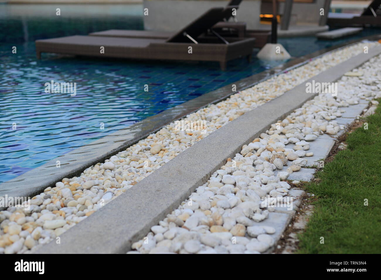 Piscine caillebotis recouvert de galets de la rivière blanche ronde. Le  système de drainage de la pelouse séparée et piscine couverte de pierre  blanche. drainage piscine Photo Stock - Alamy