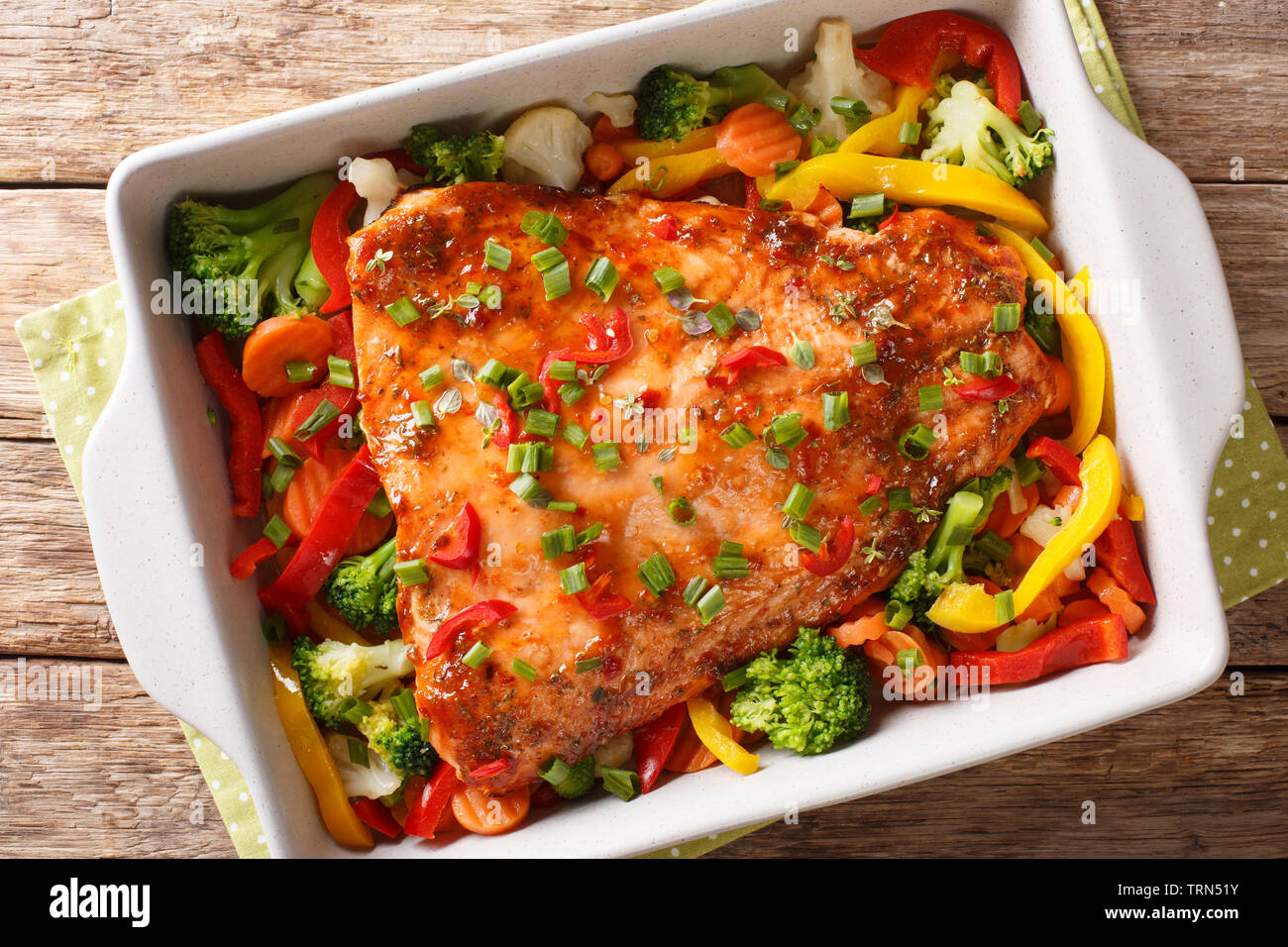 Filet de poisson rouge cuit avec les légumes, épices et fines herbes close-up dans un plat allant au four, sur la table. Haut horizontale Vue de dessus Banque D'Images
