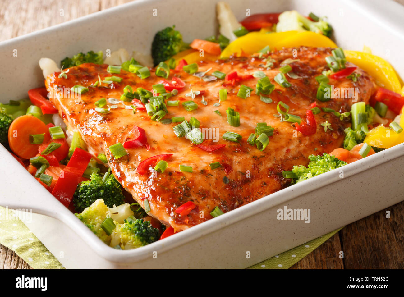 Filet de poisson rouge cuit avec les légumes, épices et fines herbes close-up dans un plat allant au four, sur la table horizontale. Banque D'Images