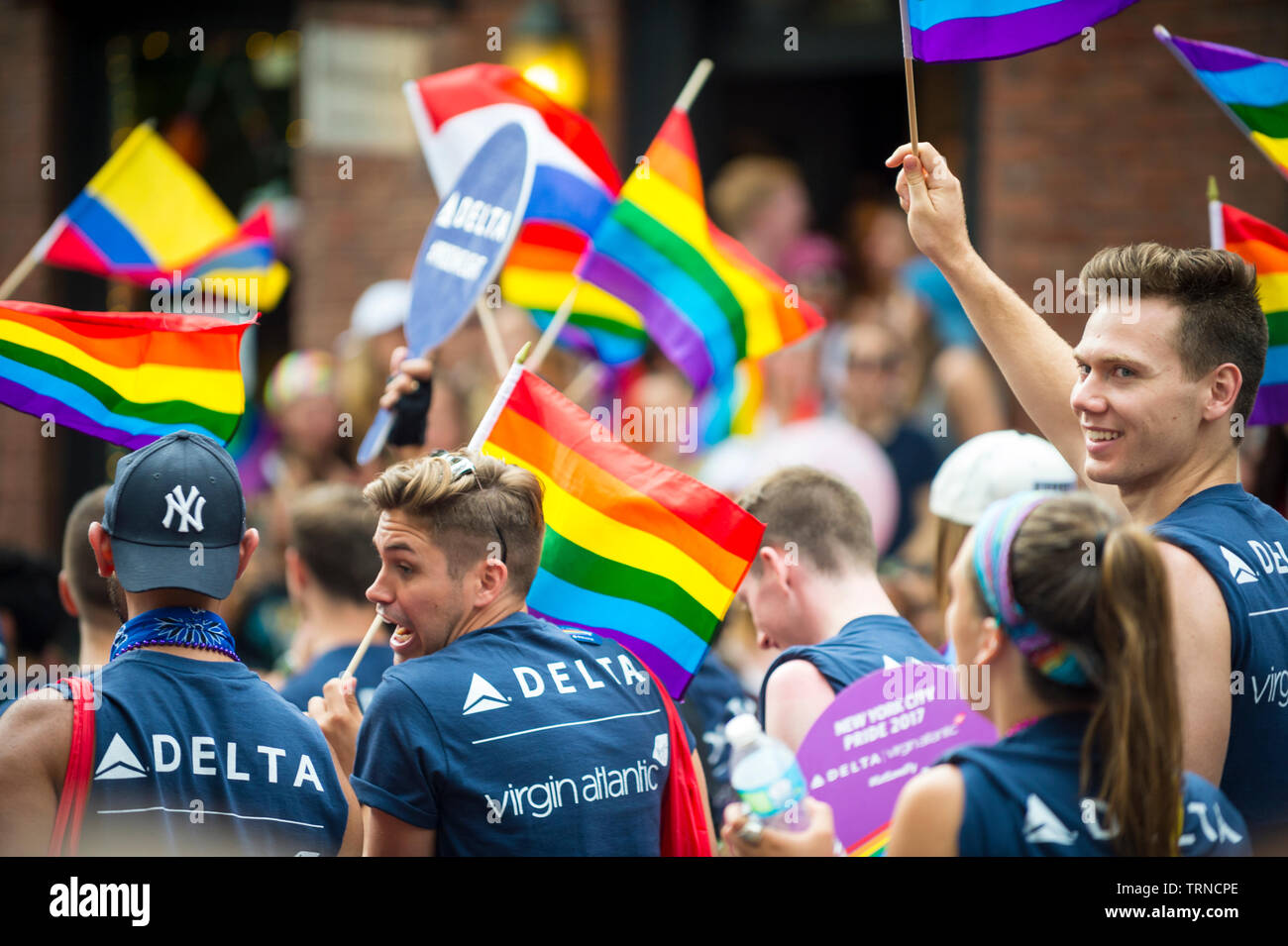 NEW YORK - 25 juin 2017 : Les participants port shirts parrainé par Delta et Virgin Atlantic Airlines drapeaux arc-en-ciel de l'onde dans la Gay Pride Parade. Banque D'Images