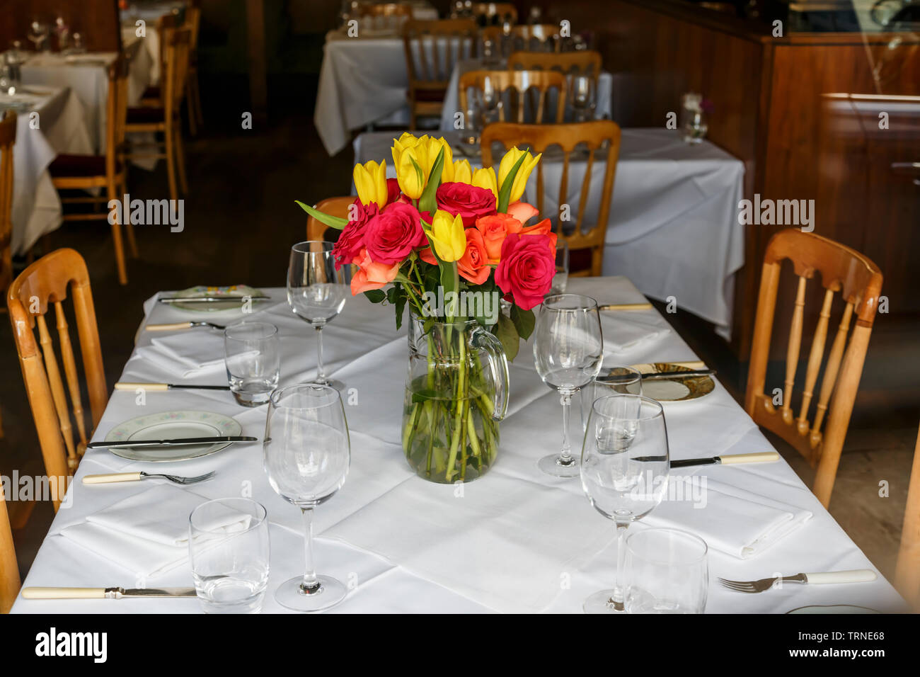 Deux restaurants FAT Dames, centre-ville de Glasgow, Blythswood Street, Écosse, Royaume-Uni. En regardant à travers une fenêtre des fleurs coupées fraîches sur une table fixe Banque D'Images