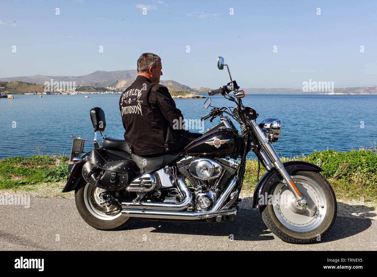 L'homme à veste en cuir sur une moto Harley Davidson par la mer en Crète, Grèce Banque D'Images