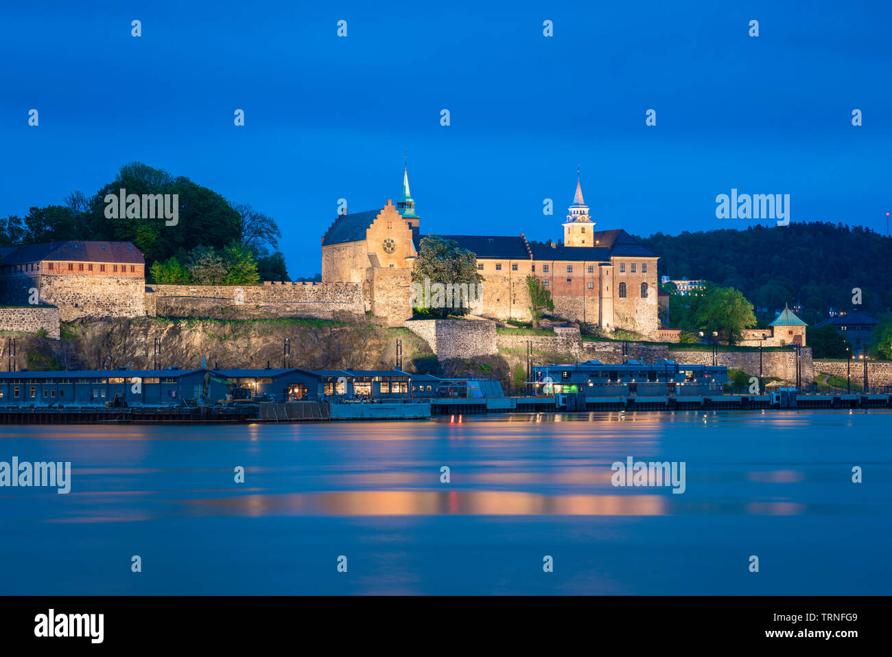 Akershus Oslo, vue de nuit sur le fjord d'Oslo en direction du complexe Akershus Festning (forteresse) situé dans le port de la ville, Oslo, Norvège. Banque D'Images