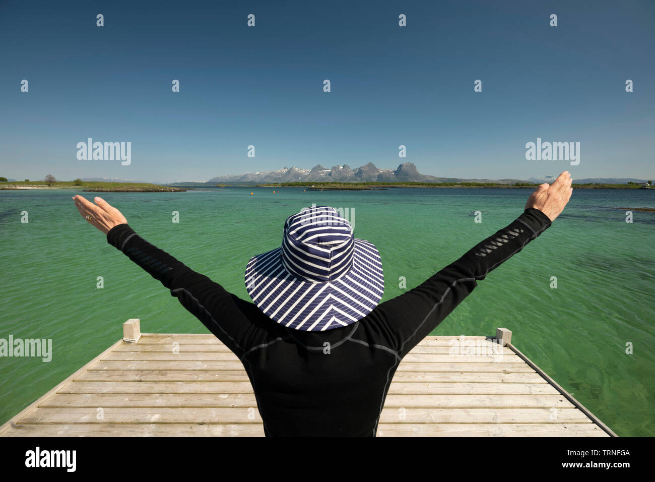 Femme au chapeau profiter de l'été météo à Heroy Island, la Norvège, l'été 2019. Banque D'Images