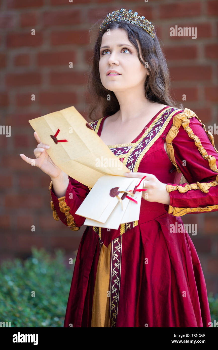 Femme en robe renaissance lisant une lettre Banque D'Images