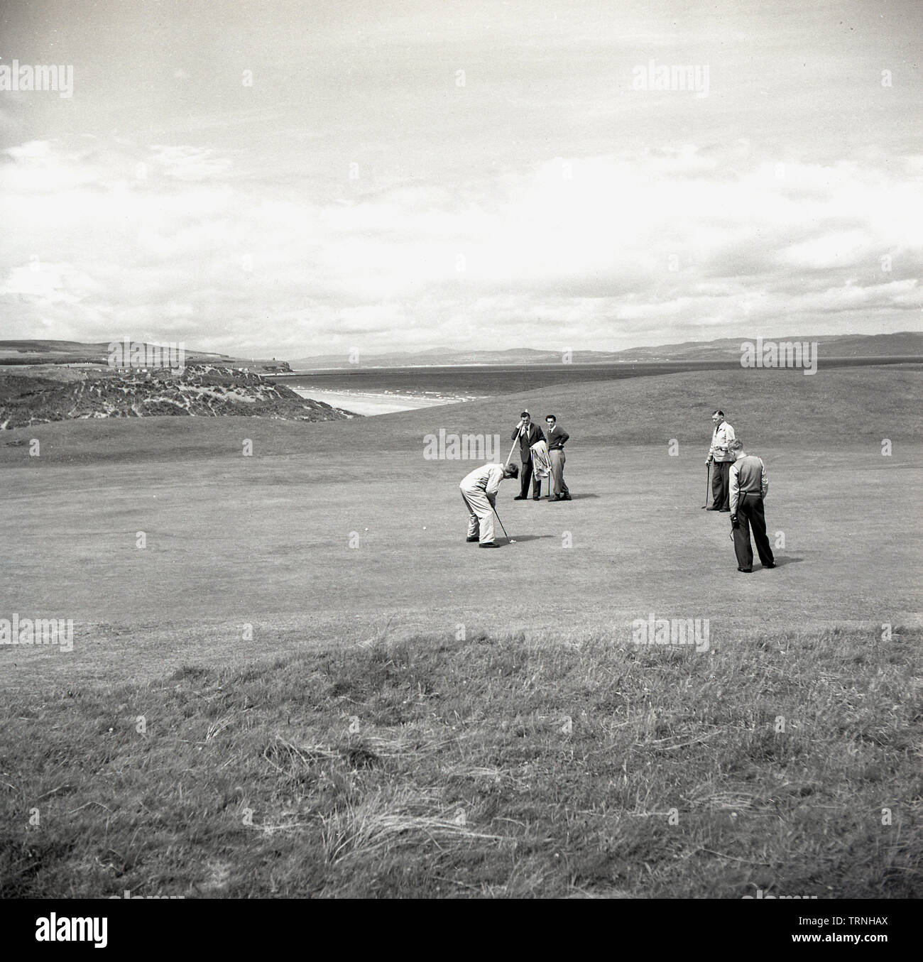 Années 1950, historiques, des golfeurs amateurs sur un green de Royal Portrush Golf Club sur le Nord de la côte de Causeway Antrim en coopération, d'Antrim, en Irlande du Nord. Banque D'Images