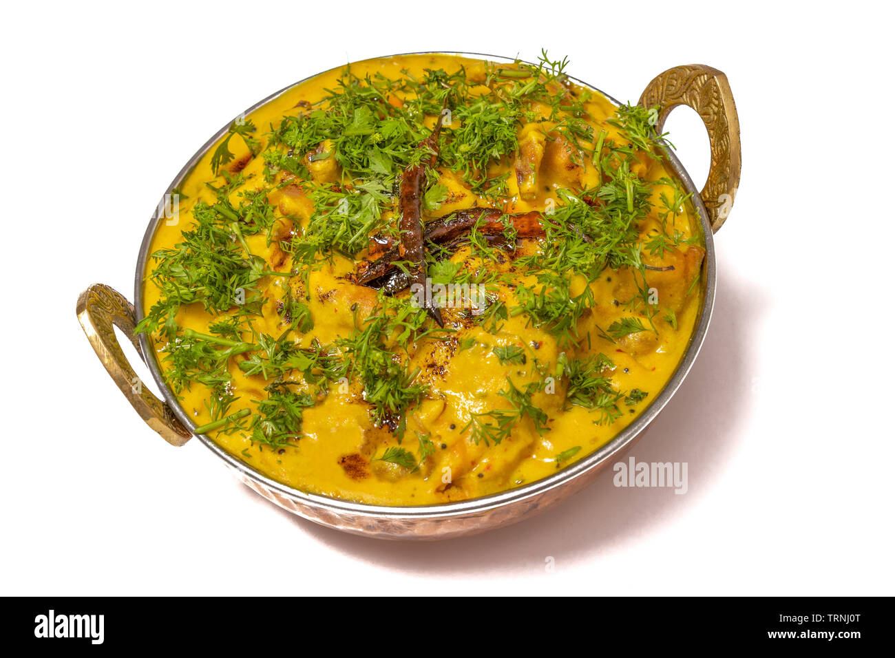 Kadhi Pakoda ou pakora, la cuisine indienne, servi dans un bol en laiton ou kadai isolé sur fond blanc. Banque D'Images