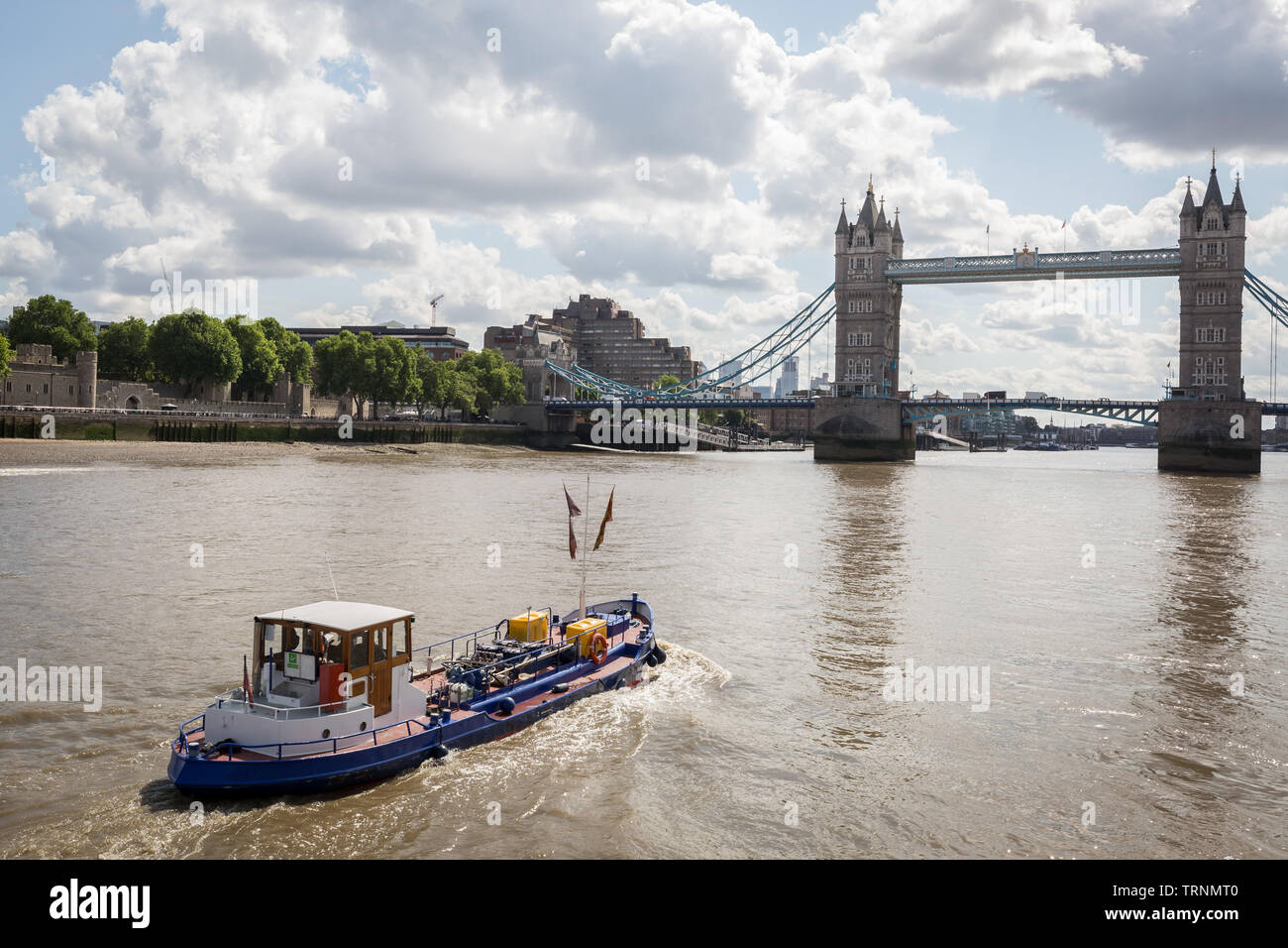 Un remorqueur de remorquage Thames fait son chemin le long de la rivière vers London Tower Bridge. London, UK Banque D'Images