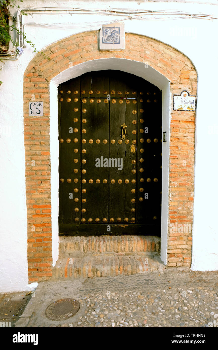 Porte d'une maison sur la Calle Santa Elena dans le quartier Albaicin à Grenade, Espagne avec un encadrement de porte en briques et tuiles avec le nom et numéro de rue. Banque D'Images