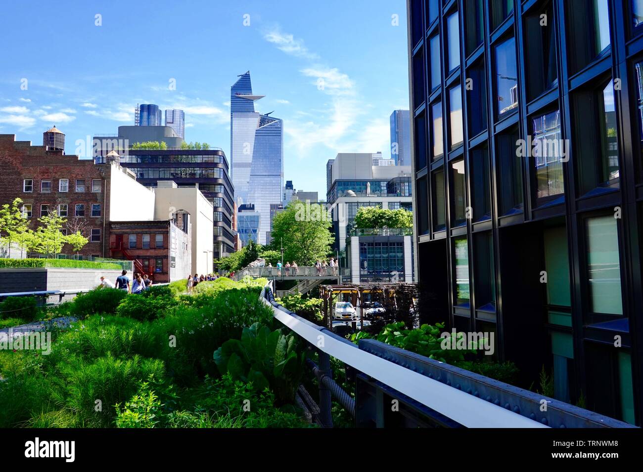 Skyline avec les gens vus de l'intérieur du parc public, converti en parc linéaire de rail, la ligne haute, New York, NY, USA Banque D'Images