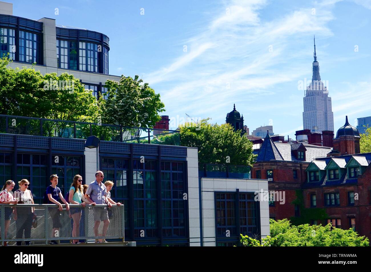 Skyline avec les gens et de l'Empire State Building en arrière-plan, à partir de l'intérieur du parc public, converti en parc linéaire de rail, la ligne haute, New York, NY, USA Banque D'Images