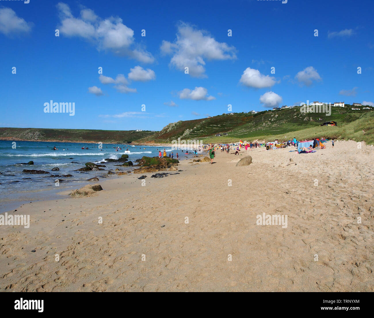 Un jour d'été ensoleillé sur la plage de Sennen Cove, Cornwall, Angleterre, Royaume-Uni montrant la plage de sable et la mer bleue sous un ciel bleu. Banque D'Images