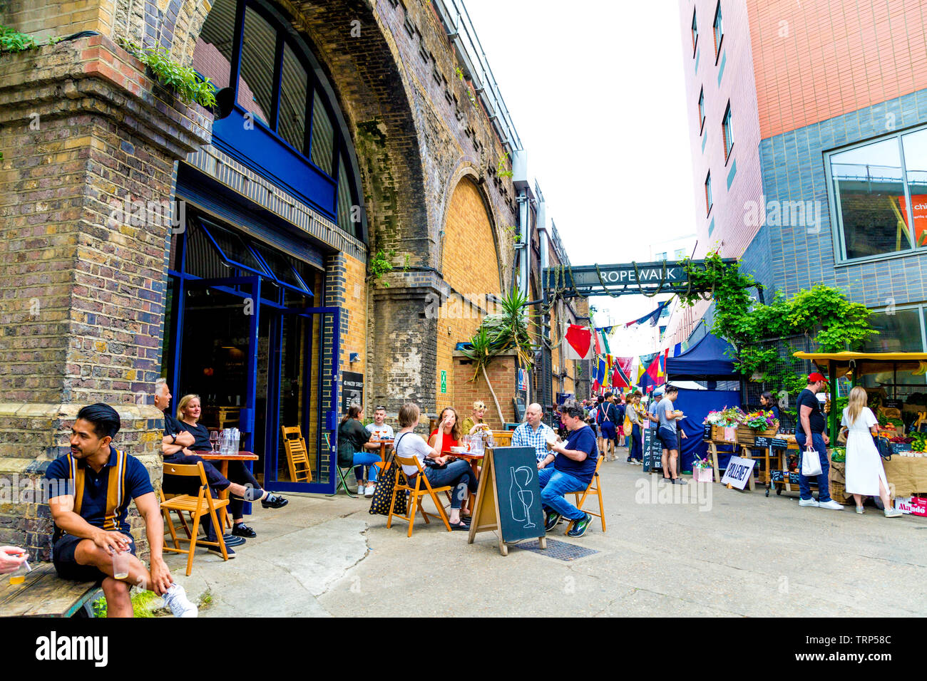 Les gens assis à des tables à Maltby Street Market, Londres, UK Banque D'Images