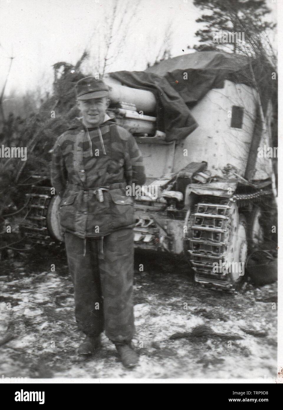 Soldat allemand camouflé en parka d'hiver se trouve en face d'une grille automoteur d'artillerie allemande sur le front de l'Est 1944 Banque D'Images