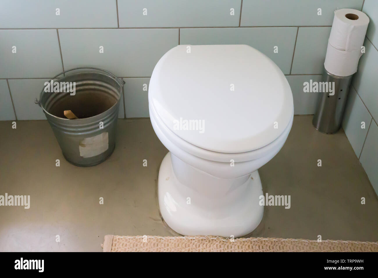 Toilettes sans eau avec un seau rempli de terre ou de compost et d'une louche pour utiliser au lieu de l'eau pour rincer à une maison écologique eco Banque D'Images