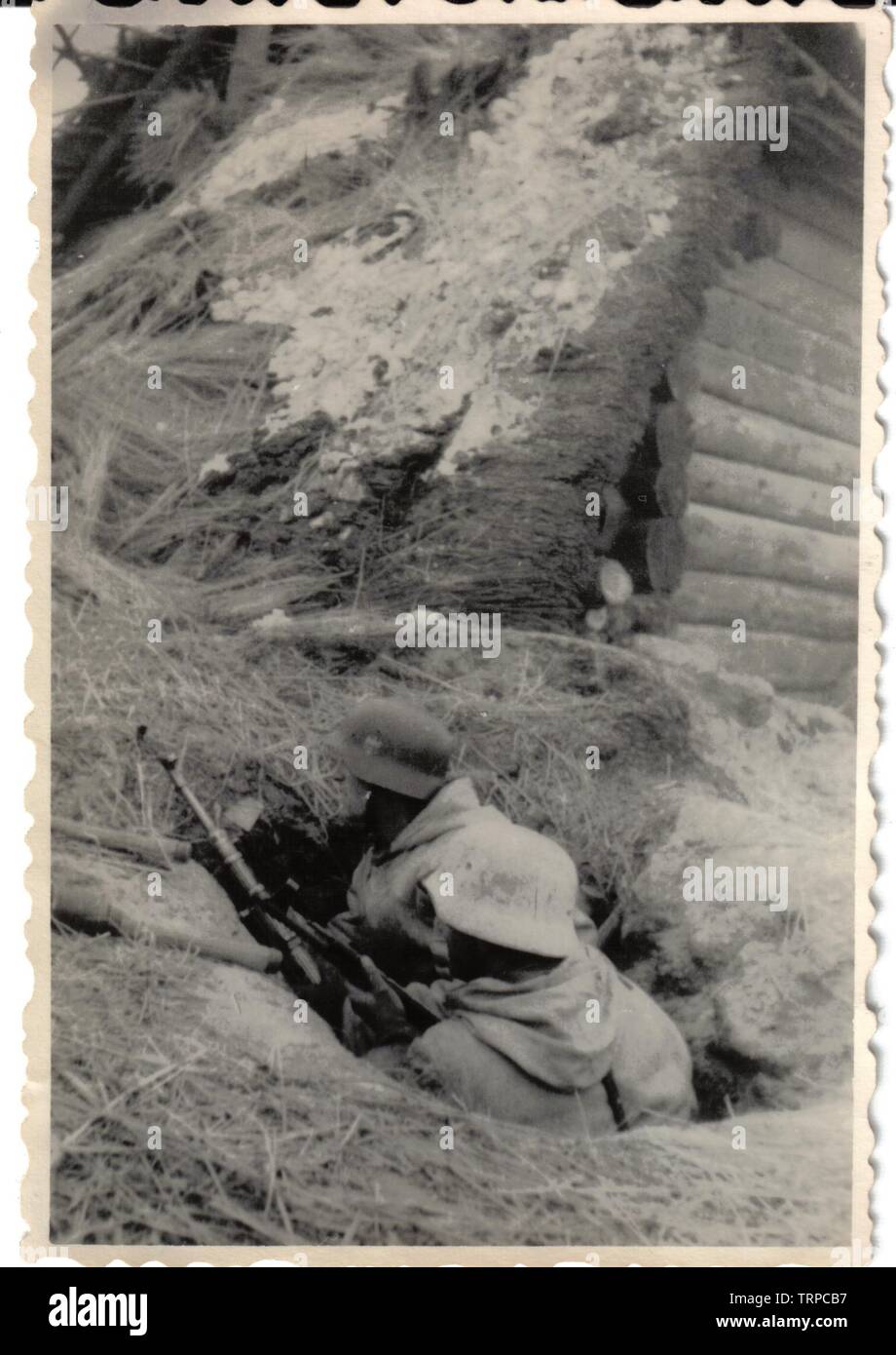 Soldat allemand en blanc Parka Camouflage dans la tranchée avec le MP44 sur le front de l'Est 1945 Banque D'Images