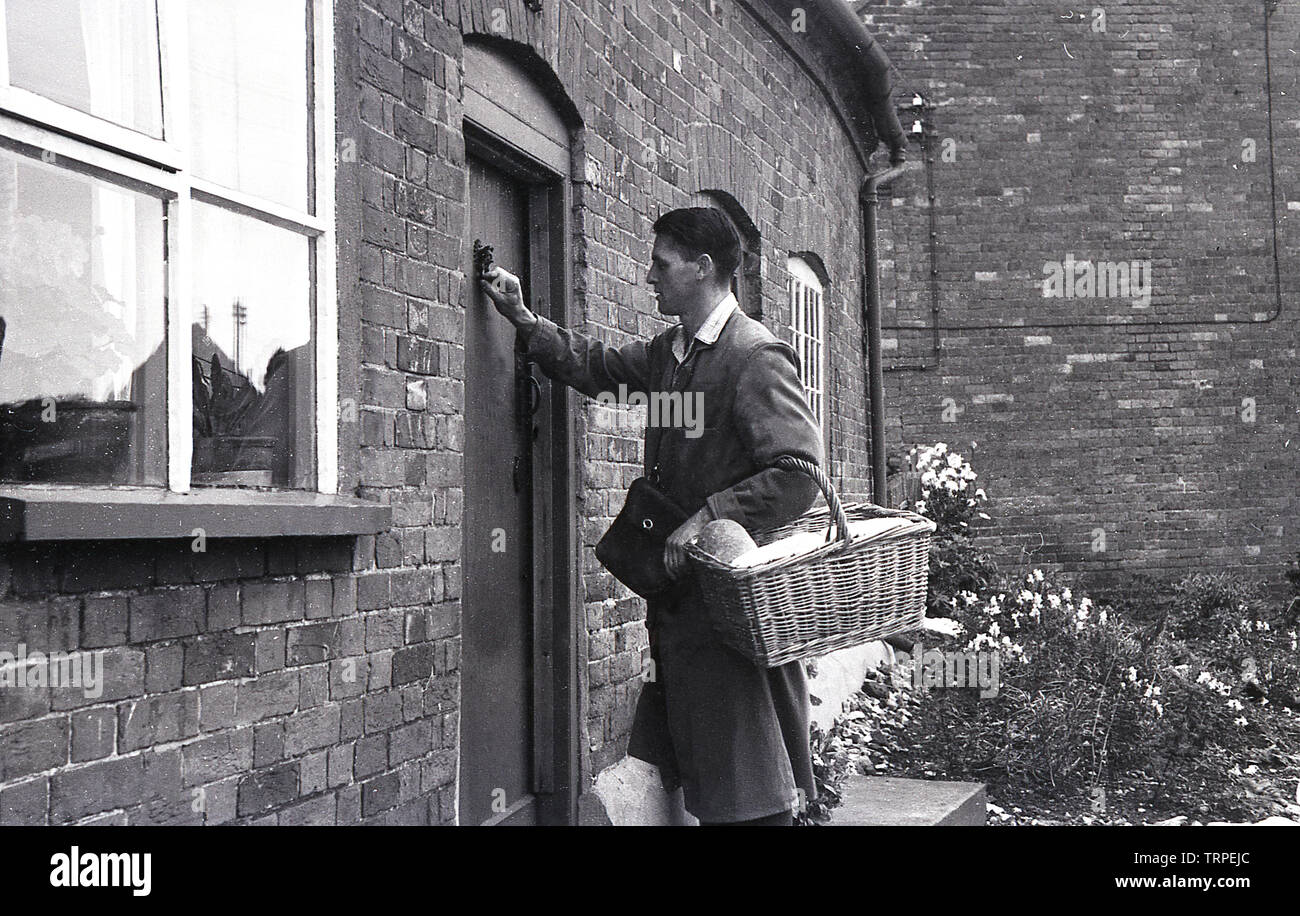 1955, historique, un boulanger avec un panier de pain cogner à une porte du client pour une livraison à domicile, quelque chose qui était assez commune dans cette ère, Aylesbury, Buckinghamshire, Angleterre, Banque D'Images