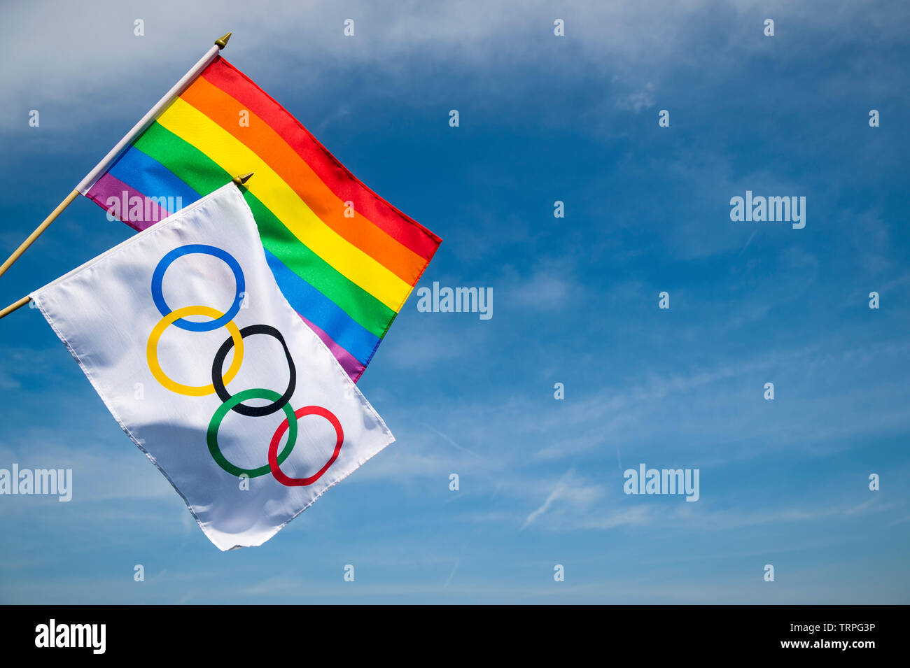 Londres - 4 mai 2019 : Un drapeau olympique se tient avec la gay pride rainbow flag sous ciel bleu ensoleillé lumineux. Banque D'Images