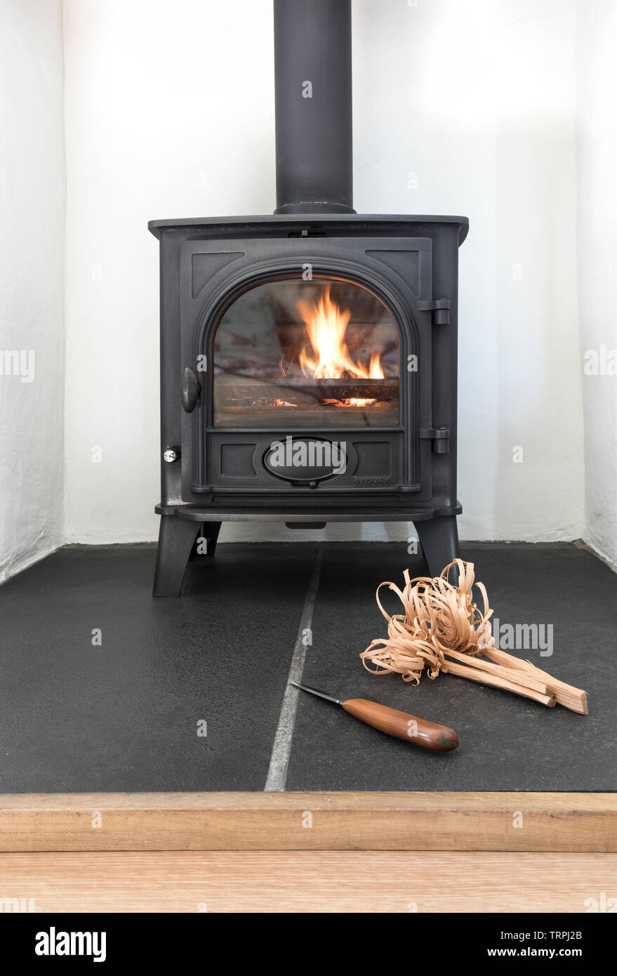 La combustion du bois/Multi-Fuel cuisinière avec des bâtons comme allumer le feu de l'éclairage, UK Banque D'Images
