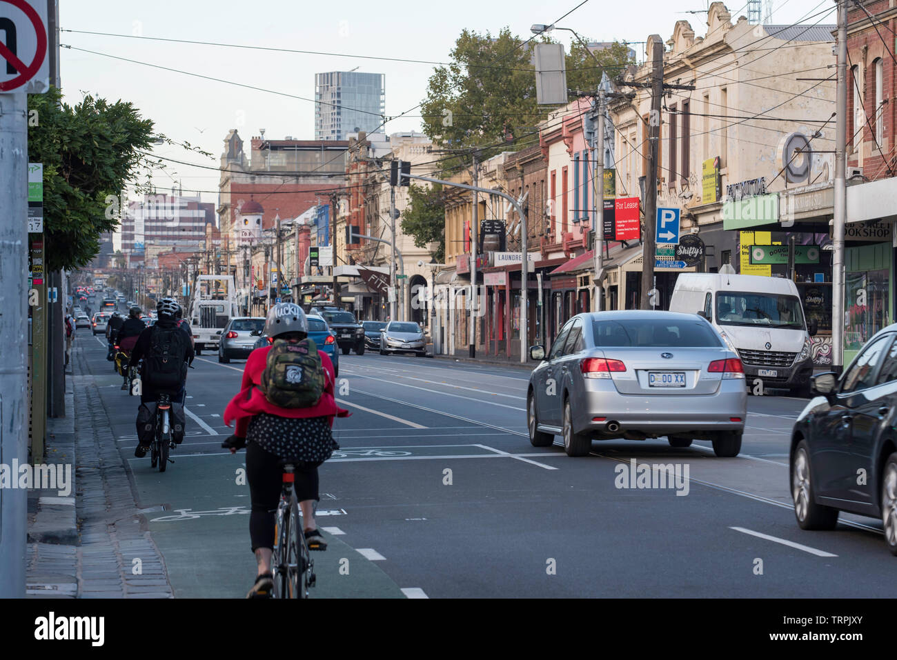 Les cyclistes parcourir la piste cyclable pendant la trajet du matin sur Fitzroy Street, à Melbourne, Victoria, Australie Banque D'Images