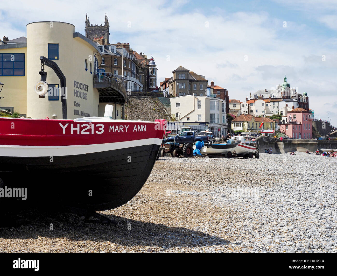 Bateaux de pêche sur la plage de galets à Cromer, Norfolk,avec le holiday resort town et de la promenade pittoresque dans l'arrière-plan. Banque D'Images