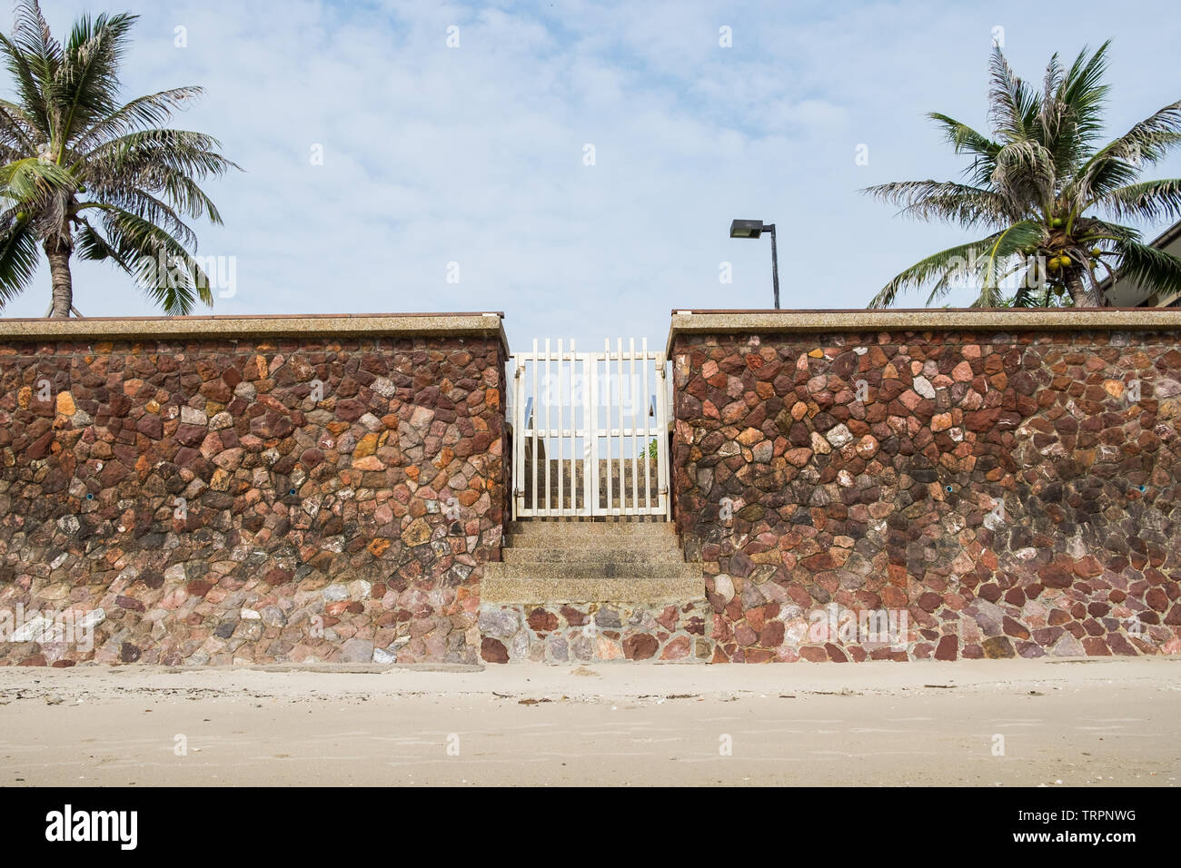 Mur de pierre porte blanche sur le sable de la plage Banque D'Images