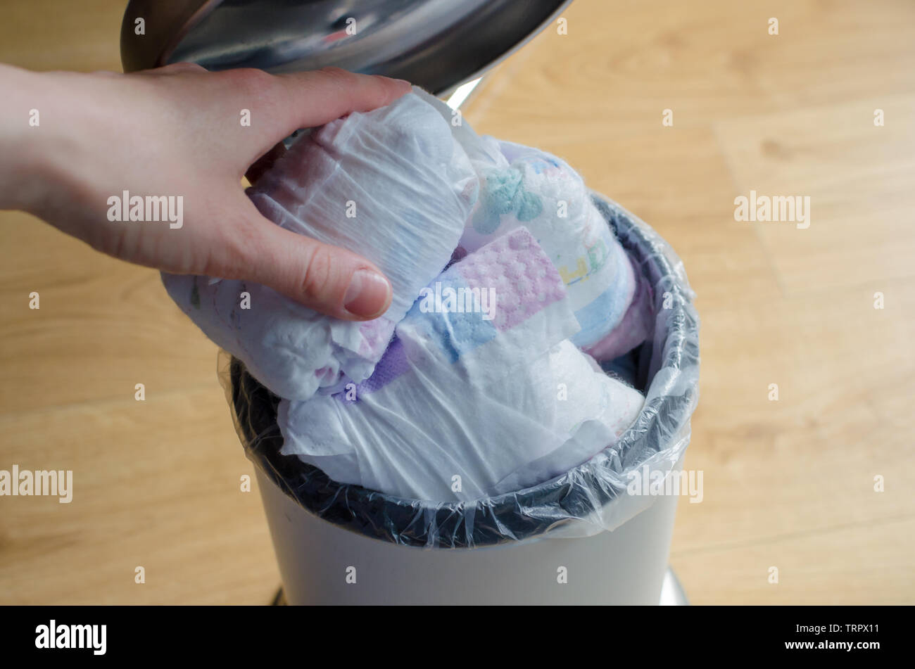 Mettre la main femme couche utilisé à la poubelle pleine de couches  utilisées. Close up Photo Stock - Alamy