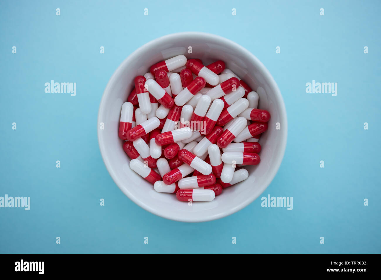 Bol de médicaments comprimés capsules sur fond de couleur bleu Banque D'Images