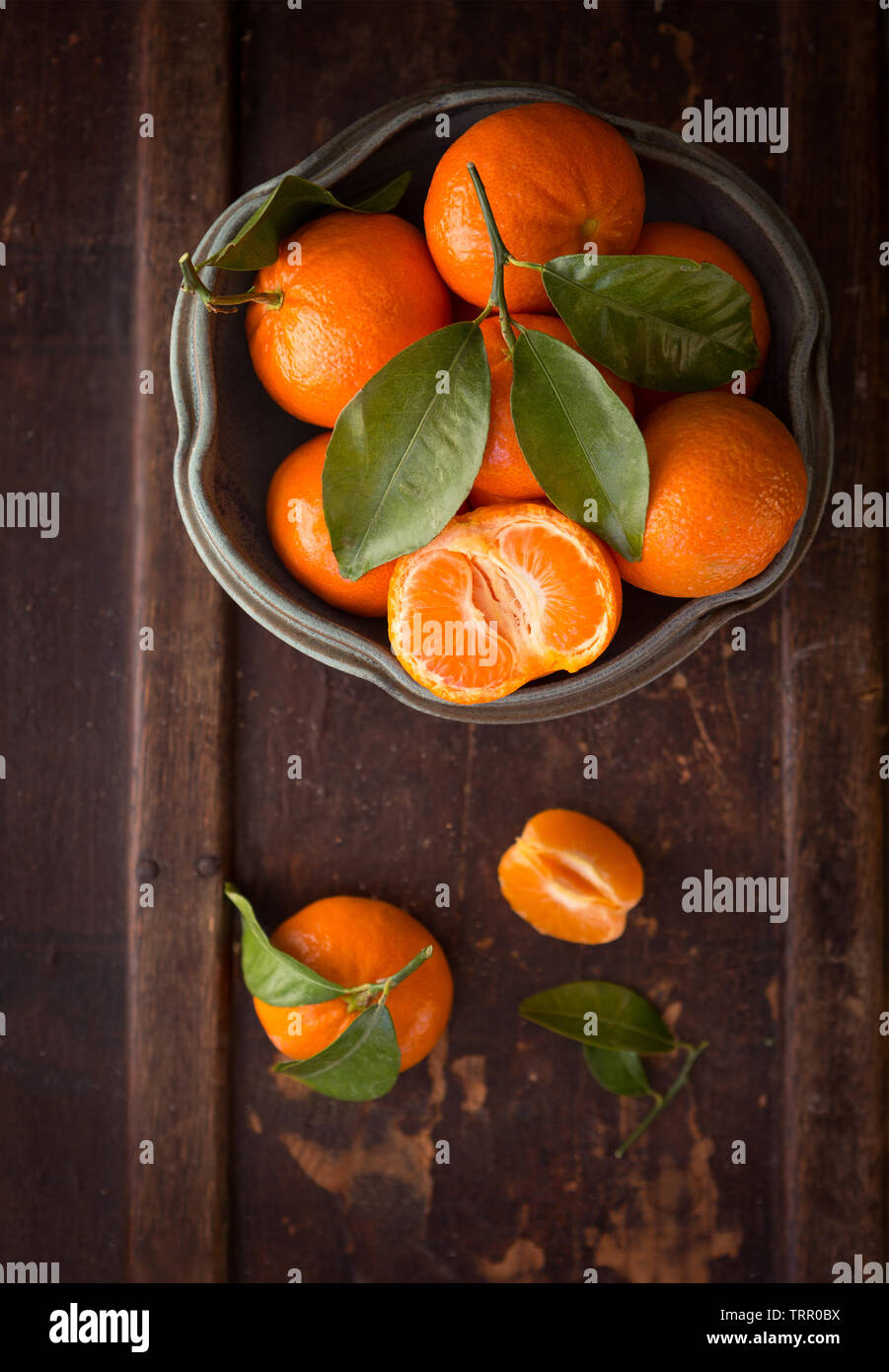 Vue de dessus de la mandarine sur une surface en bois sombre dans un bol en faïence Banque D'Images