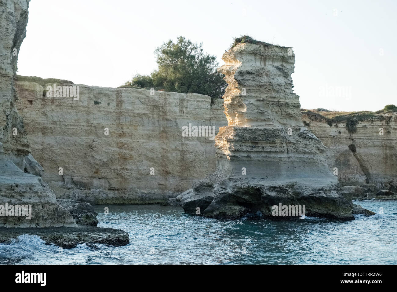Vue sur les Faraglioni de Sant Andrea dans près de Salento Otranto, majestueux rochers à quelques mètres de la côte sud de l'Italie. Banque D'Images