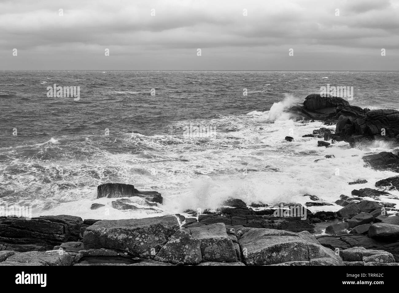 Point de Porth Hellick à marée basse et dans un fort vent onshore, St Mary's, Îles Scilly, UK : version noir et blanc Banque D'Images
