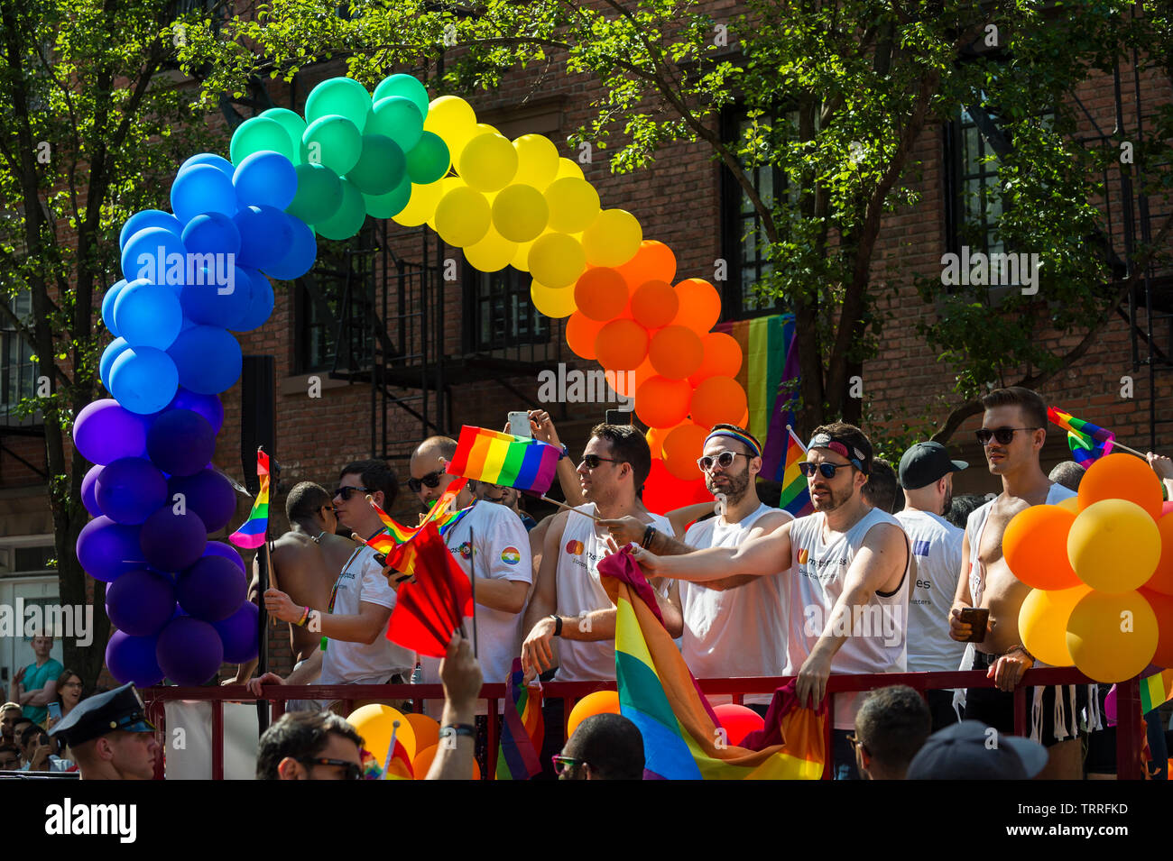 NEW YORK - 25 JUIN 2017 Participants : drapeaux arc-en-ciel de l'onde sur un flotteur coloré décoré avec des ballons dans la Gay Pride Parade dans le village. Banque D'Images