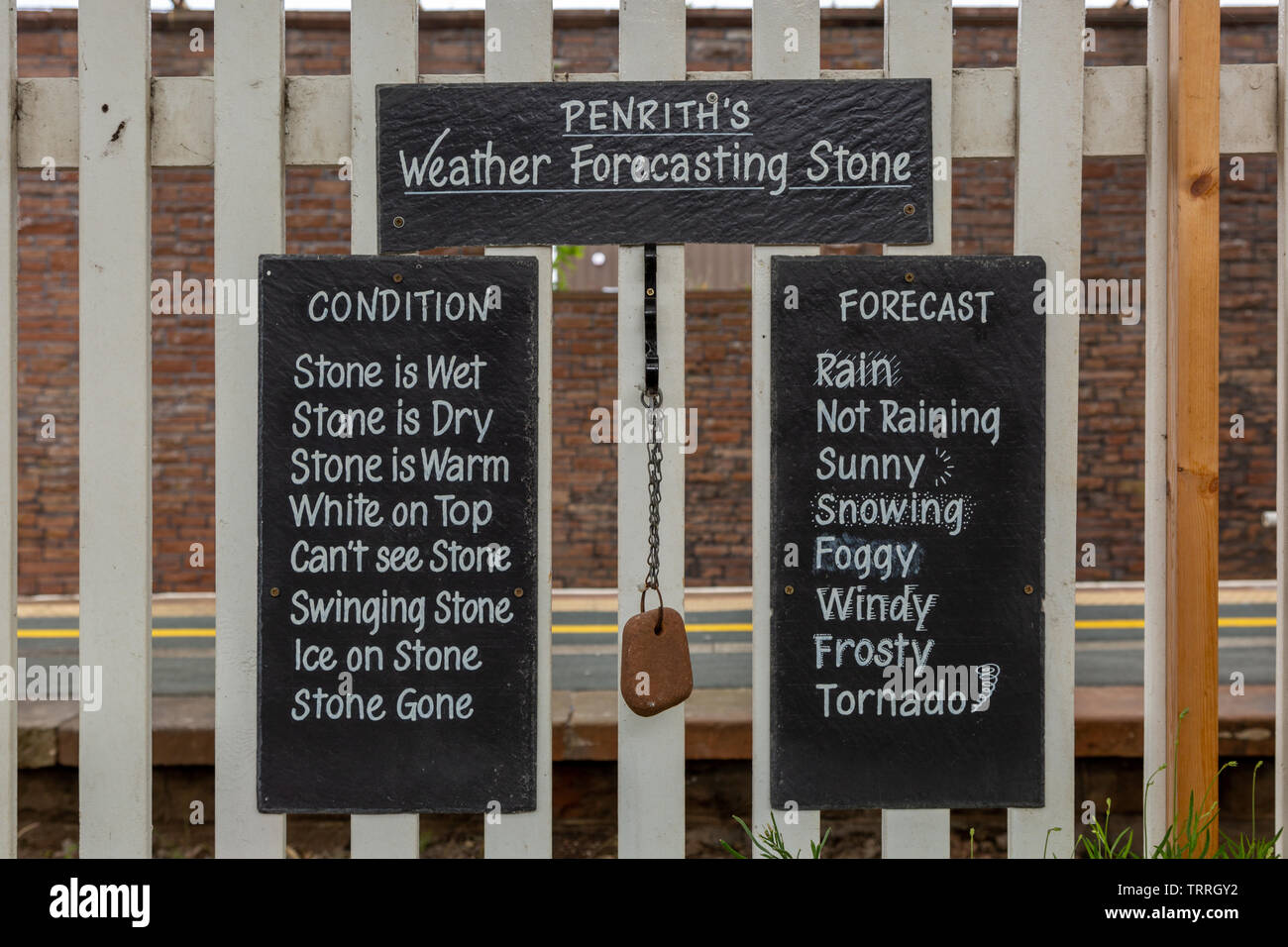 Prévisions météorologiques 'amusant' conseil pierre sur une gare ferroviaire à Penrith, Cumbria, Royaume-Uni Banque D'Images