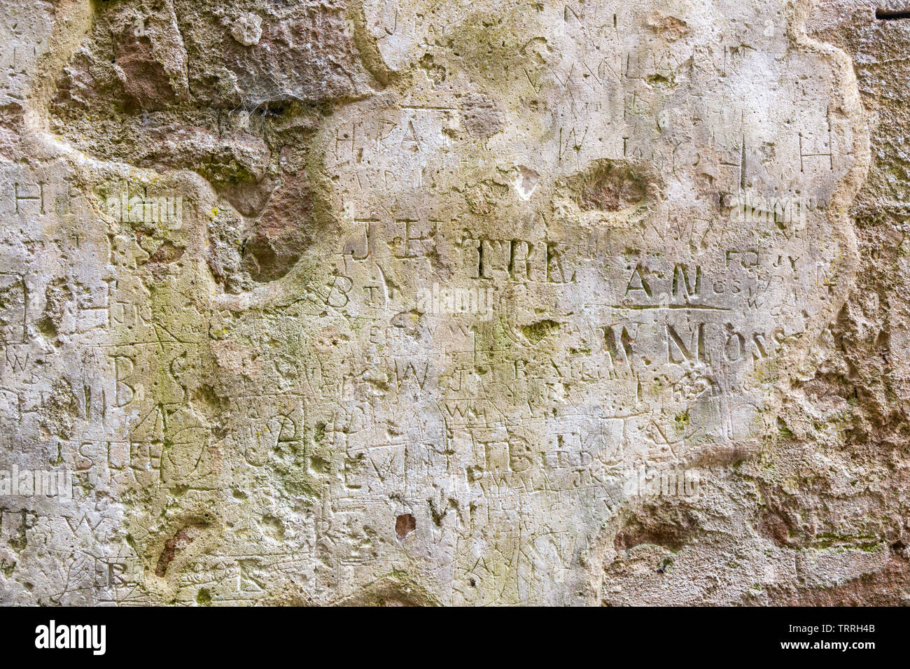 Les noms rayés dans un mur de plâtre, d'il y a des siècles, Brougham Castle, Penrith, Cumbria UK Banque D'Images