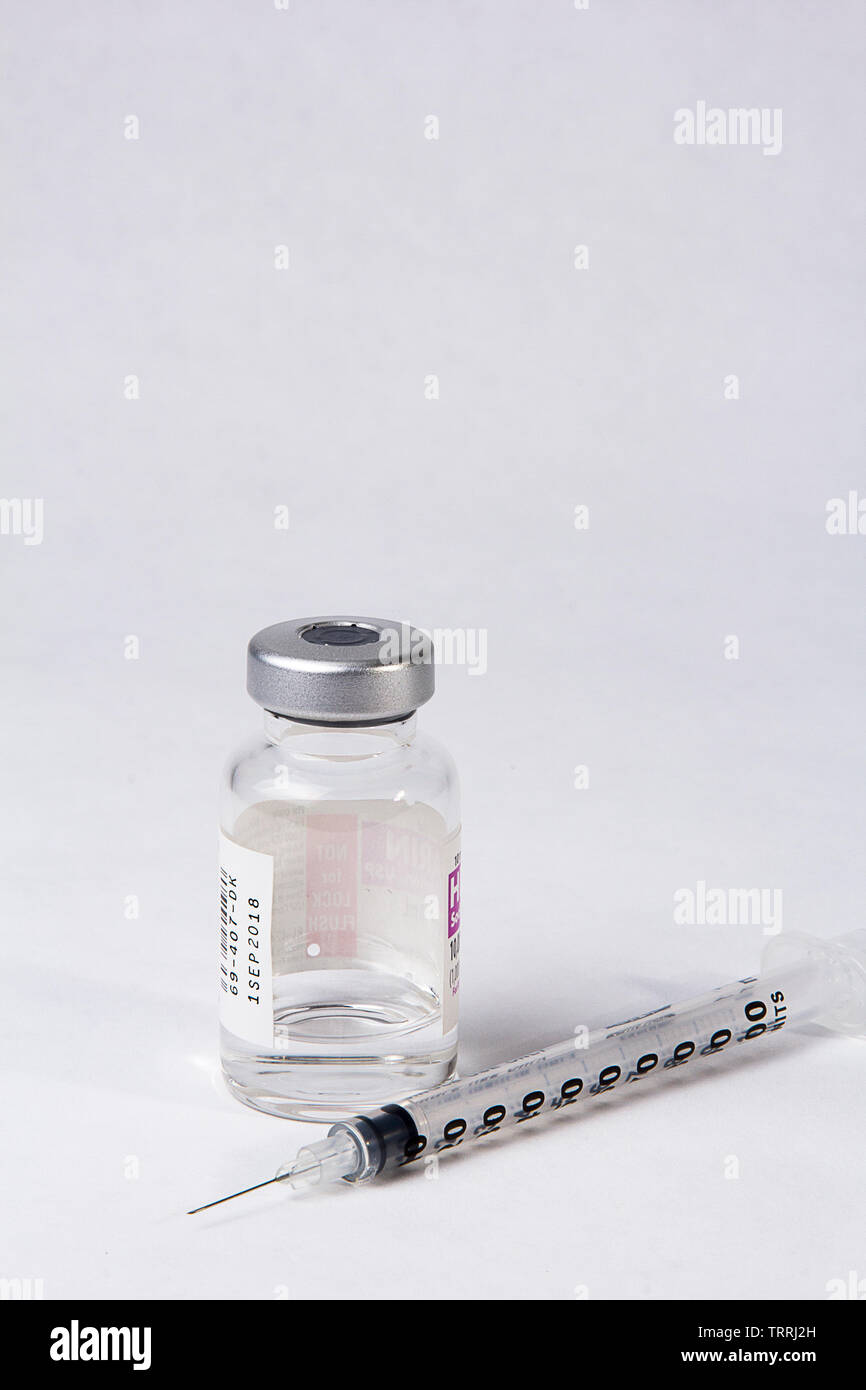 Une bouteille de l'anticoagulant Héparine sodique avec une seringue sur un fond blanc Banque D'Images