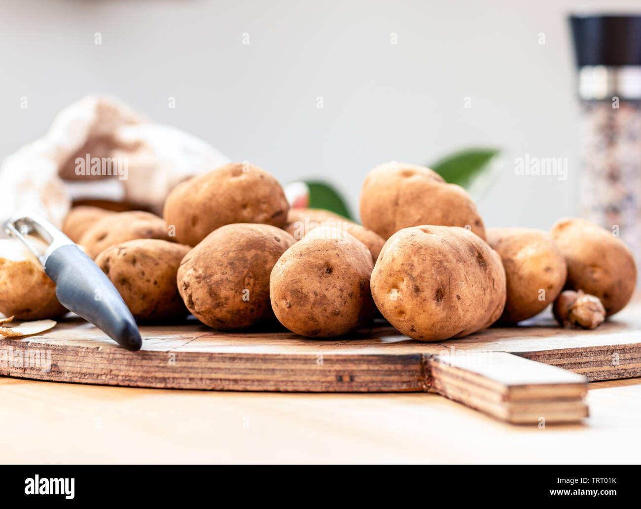 Des pommes de terre non pelées sur une planche avec une faible profondeur de champ Banque D'Images