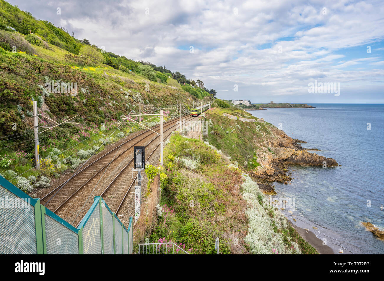 Voie de chemin de fer à côté de la baie de Killiney, comté de Dublin, Irlande avec Dart Dublin Killiney train approchant du nord Banque D'Images