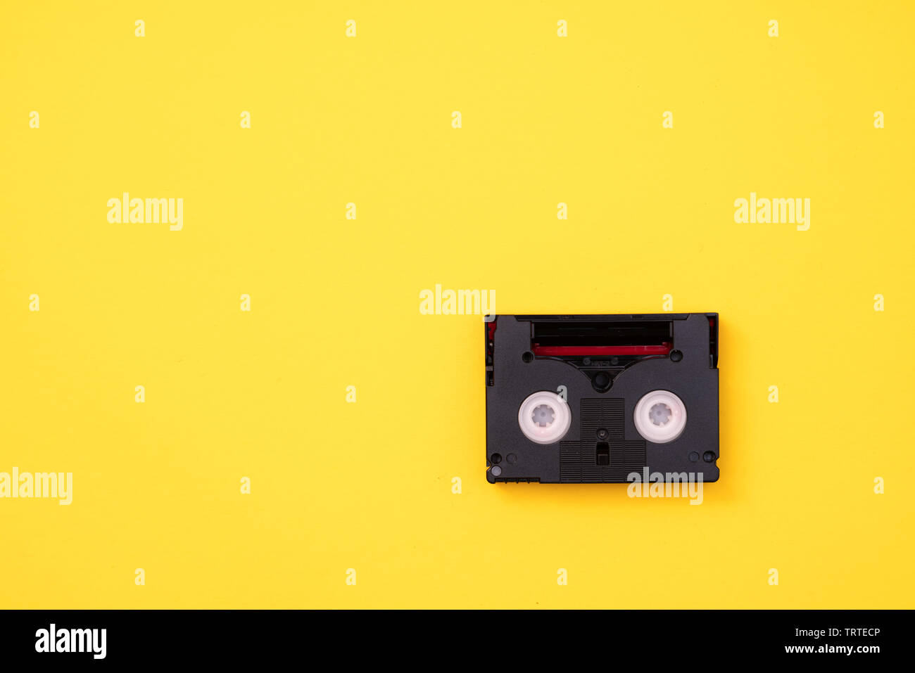 Vintage mini cassette DV utilisé pour l'enregistrement vidéo retour dans une journée. Plastique, ruban magnétique, film analogique sur fond jaune Banque D'Images