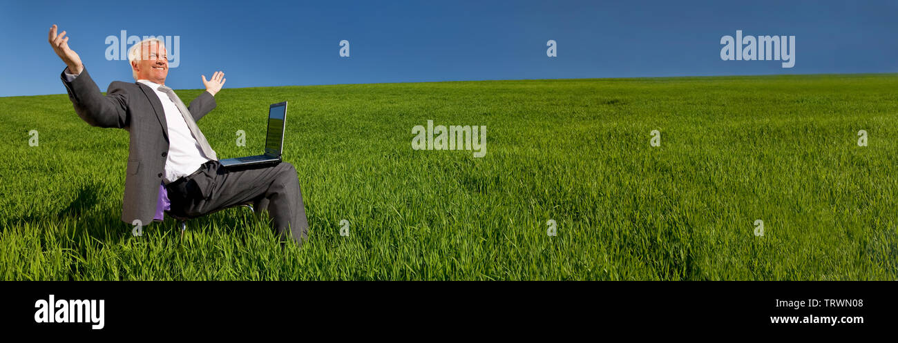 Vue panoramique de l'environnement vert bandeau web business pension concept d'homme d'affaires célèbre à l'aide d'un ordinateur portable dans un champ vert avec un bleu Banque D'Images