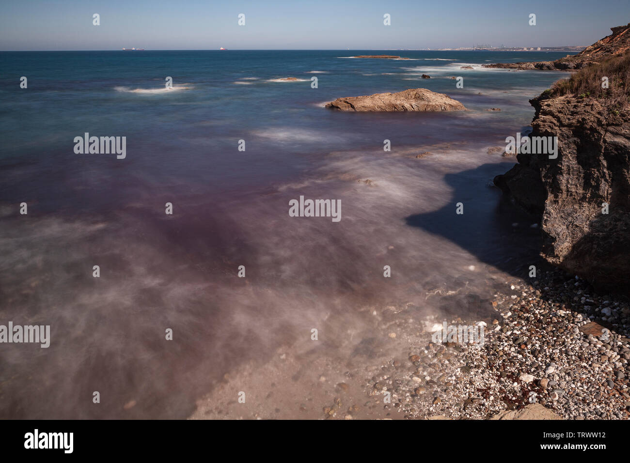 Route des pêcheurs, dans le sud-ouest du Portugal, avec ses formations rocheuses et l'eau cristalline, avec des tons de rouge que les algues donne à l'eau. Banque D'Images