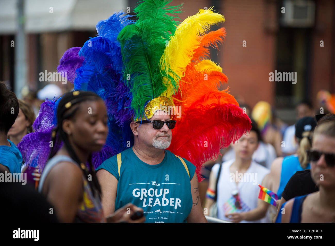 NEW YORK - 25 juin 2017 : un homme portant une coiffe de plumes de couleur arc-en-ciel flamboyant promenades dans la Gay Pride Parade annuelle à Greenwich Village Banque D'Images