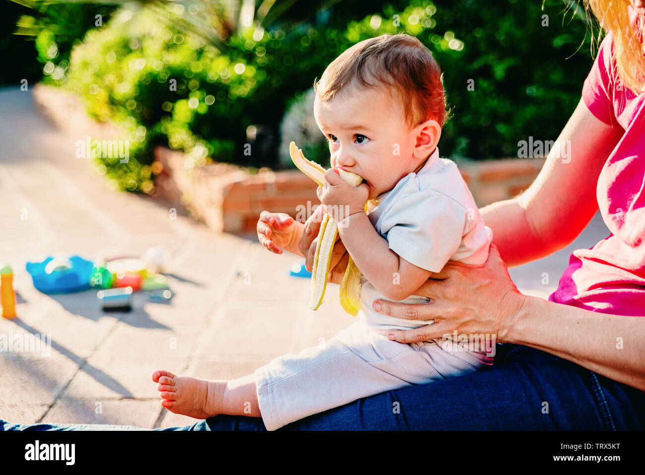 Bebe Dans Les Bras De Sa Mere D Apprendre A Manger Des Aliments Solides Comme Les Fruits Crus Blw Photo Stock Alamy