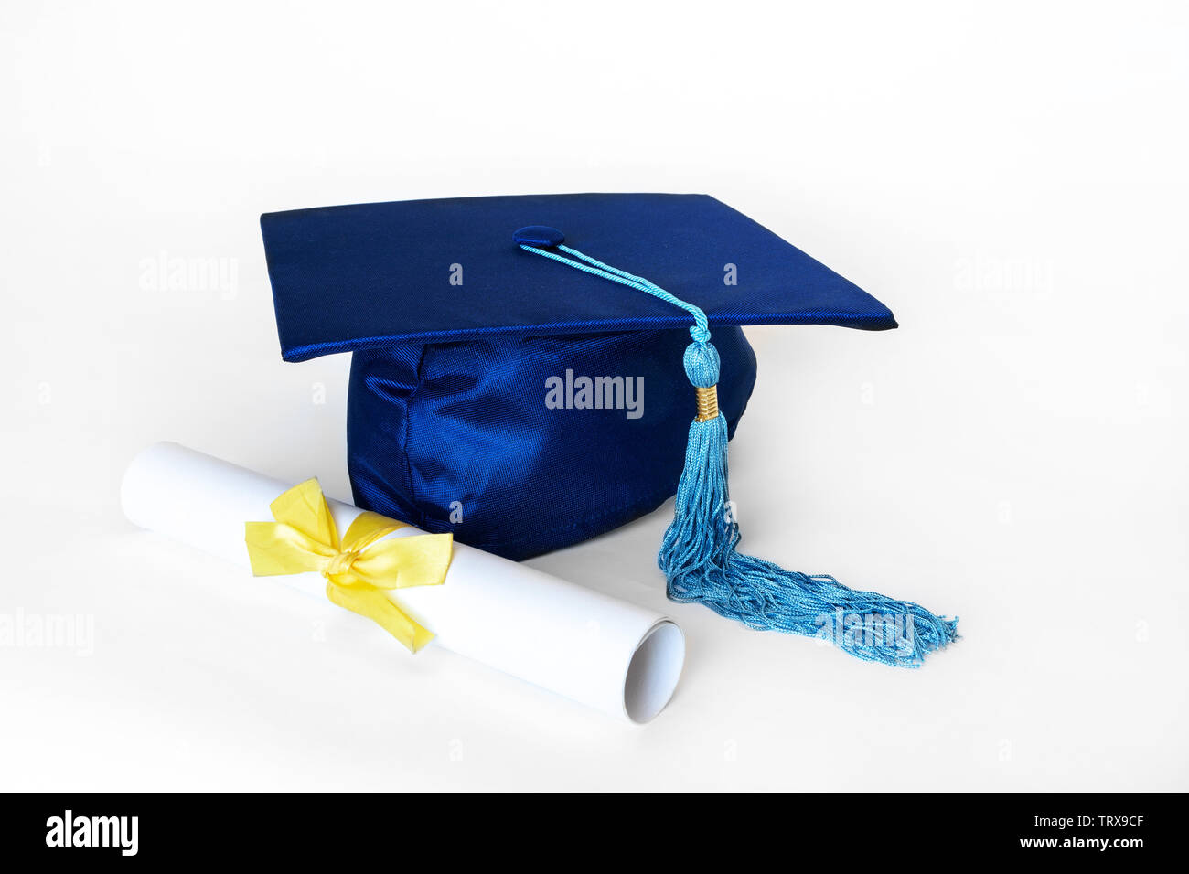 Graduation cap bleu ou mortier avec blue tassel et diplôme avec ruban jaune, isolé sur fond blanc. Banque D'Images